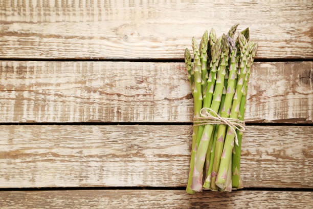 istock Bunch of green asparagus on grey wooden table 970792246