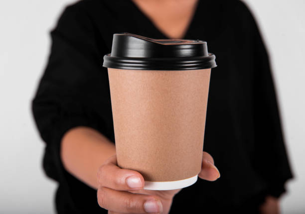 istock Hand holding coffee paper cup. mock up for creative design branding. 970798718