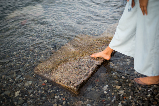 Close up of woman foot entering to water.