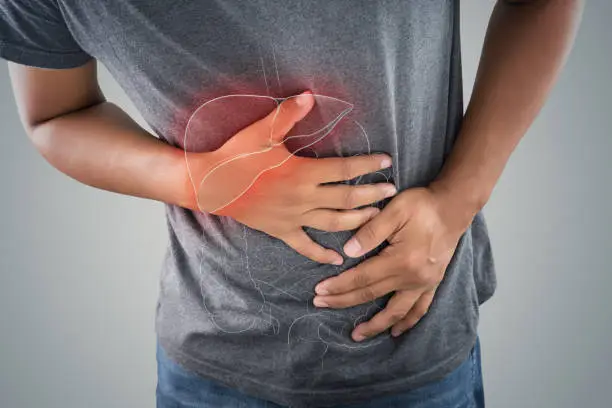 Photo of The photo of large intestine is on the man's body against gray background, People With Stomach ache problem concept, Male anatomy