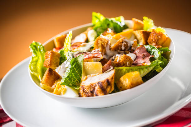 istock Delicious salad caesar with grilled chicken breast croutons eggs bacon parmesan cheese and  lettuce with dressing 970803466