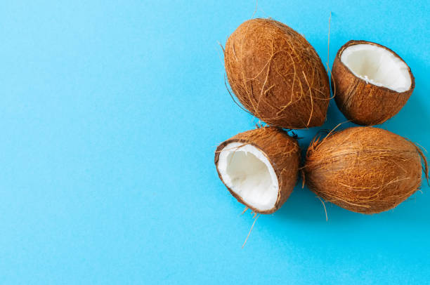 istock Whole and halfs of coconuts on a blue background. Top view and copy space. 970806748