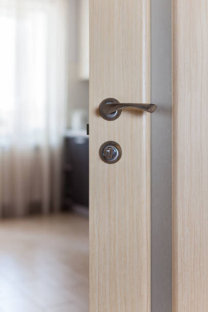 istock Wooden door with metallic handle open in to the empty room 970809830