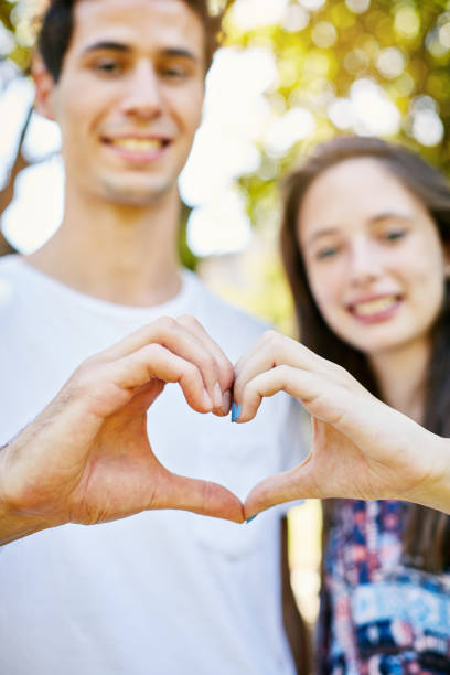 istock Young couple in love make heart shape with hands, smiling 970810332