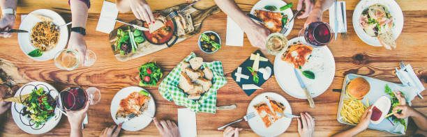 istock eating and leisure concept - group of people having dinner at table with food 970818986