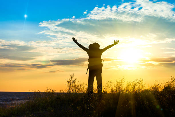 istock A tourist welcomes the rising sun  on a seaside 970819158
