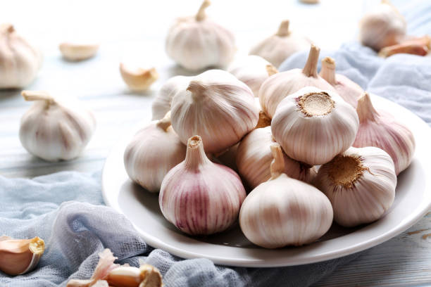 istock Garlic in plate on blue wooden table 970822736