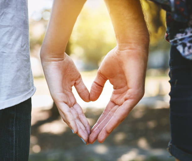 istock Rear view of couple making heart shape with hands 970822954