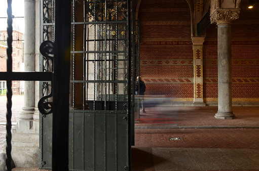 A passerby and cyclist passing the tunnel of Amsterdam.