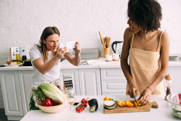 istock young man shooting on smartphone african american girlfriend cutting vegetables 970826402