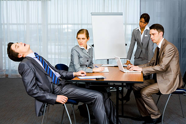 istock Man in meeting room sleeping while other workers stare 97083412