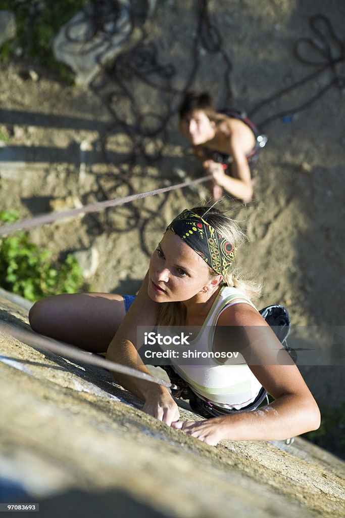 Downward view of a woman rock climbing with friend Photo of woman climbing on the rock and man standing by her  Active Lifestyle Stock Photo