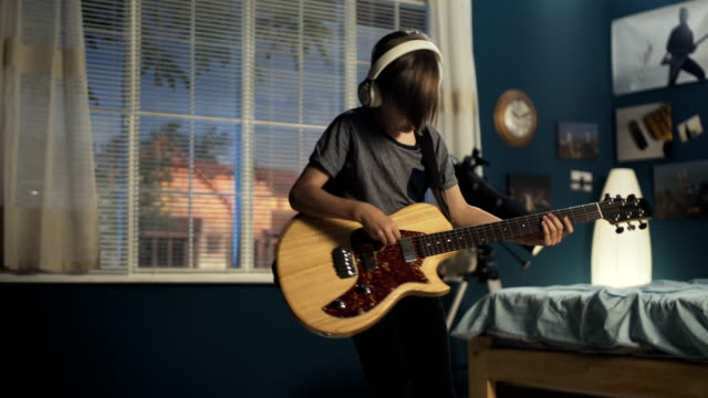 Youngster with guitar in bedroom