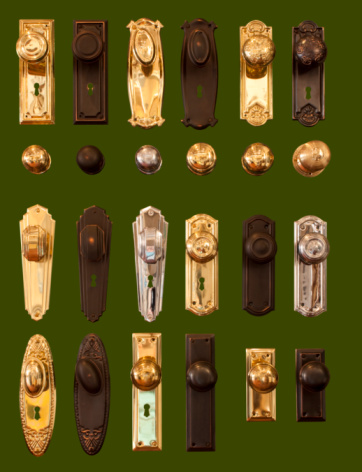 Display of brass door handles in hardware shop isolated on dark green background