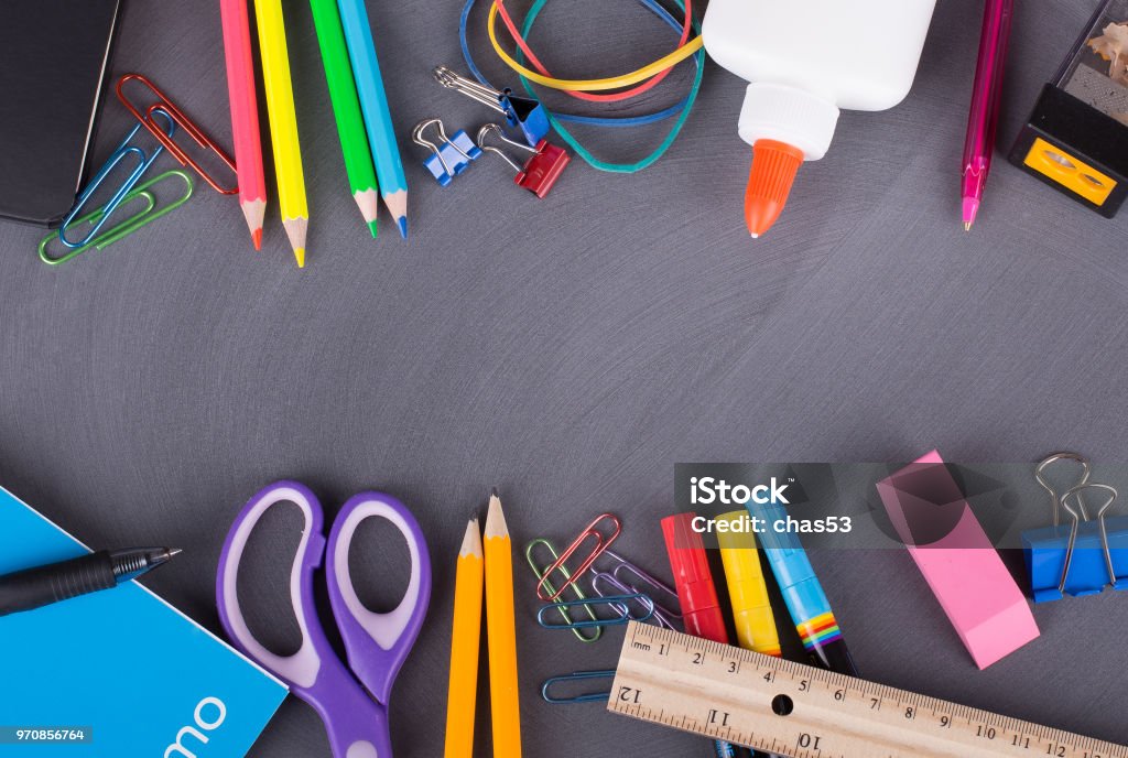 Back To School Supplies Border of an assortment of school supplies on a blackboard background with copy space School Supplies Stock Photo