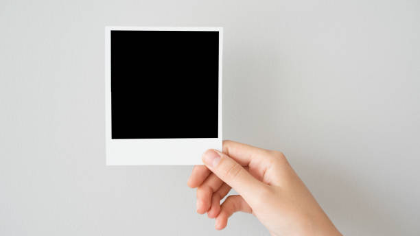 Hand holding blank photo frame stock photo