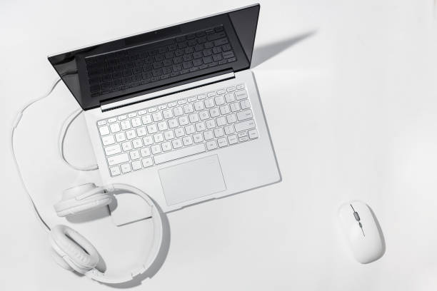 istock Laptop, White headphones and wireless mouse on a white background. Flat lay with copy space 970866984