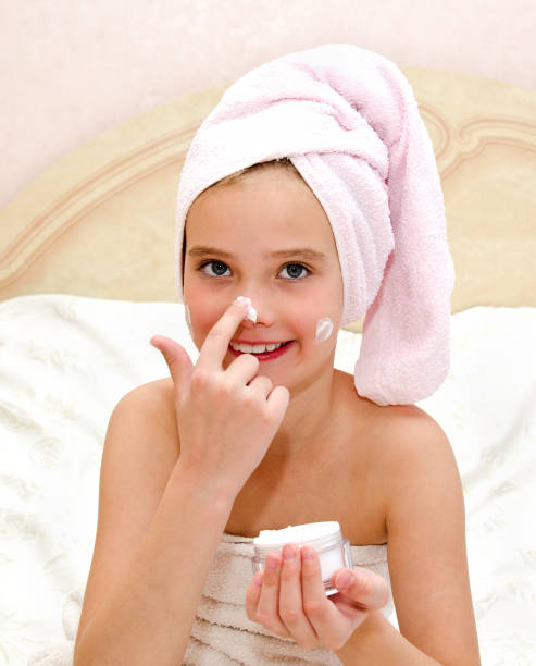 istock Happy cute little girl child applying cream 970867430