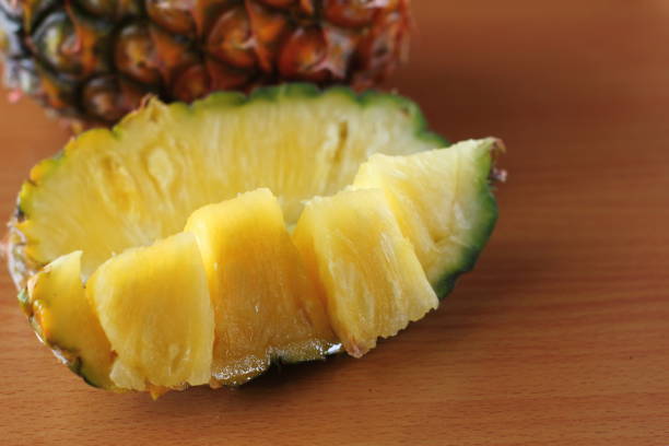 istock Ripe pineapple and pineapple slices on wooden 970868128