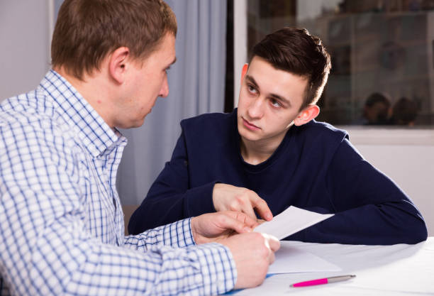 istock Adult male with his anxious son are looking in documents about studies 970868248