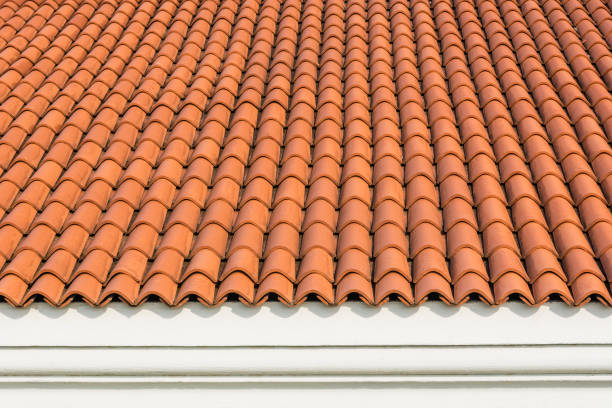 New Red corrugated tile element of roof at house and white wall. Shingles roofing surface tiles overlay pattern and texture