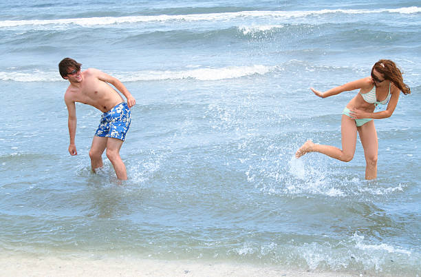 Young couple playing on the beach stock photo