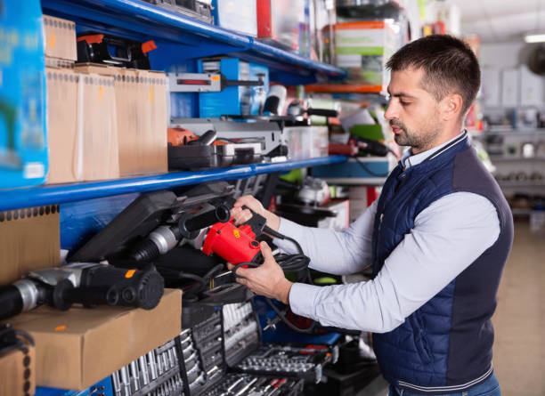 istock Adult male is standing with puncher in tools store. 970872874