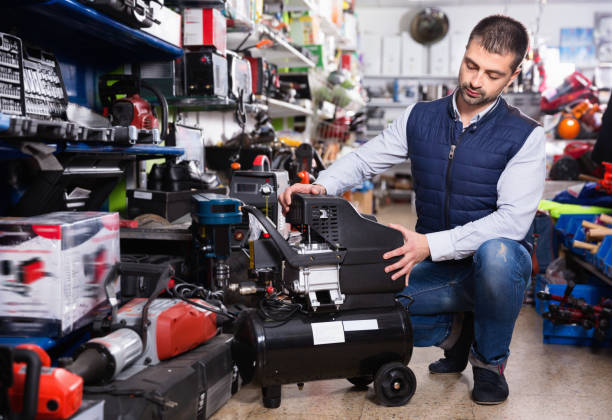 istock Adult male is standing with air compressor in tools store. 970872950