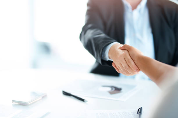 Bring the best, become even better Cropped shot of two businesswomen shaking hands during a meeting in a modern office global business handshake stock pictures, royalty-free photos & images