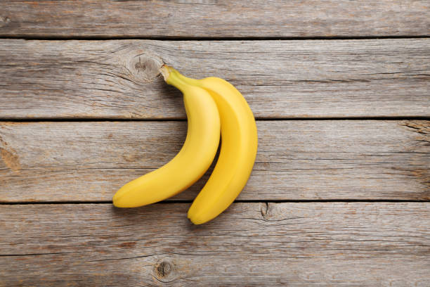 istock Sweet bananas on grey wooden table 970883674
