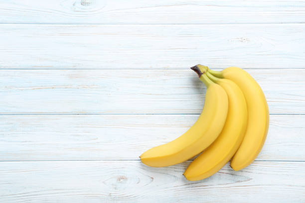 istock Sweet bananas on white wooden table 970888300