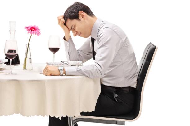istock Disappointed young man sitting at a restaurant table 970888406