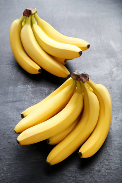 istock Sweet bananas on grey wooden table 970888554
