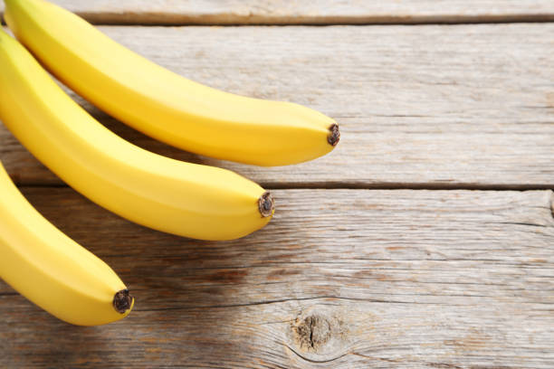 istock Sweet bananas on grey wooden table 970888804