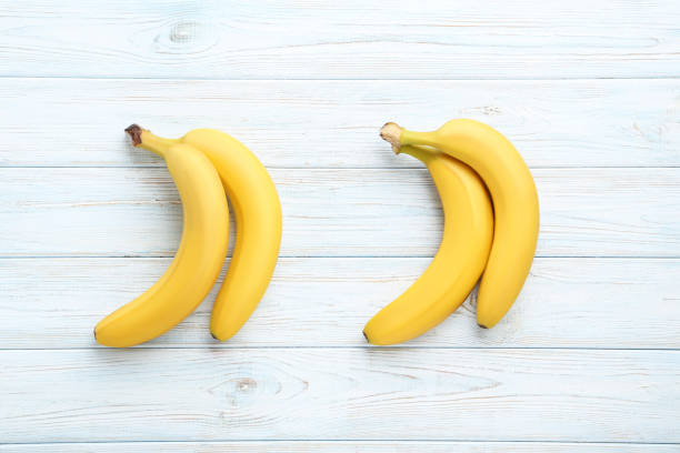 istock Sweet bananas on white wooden table 970889016
