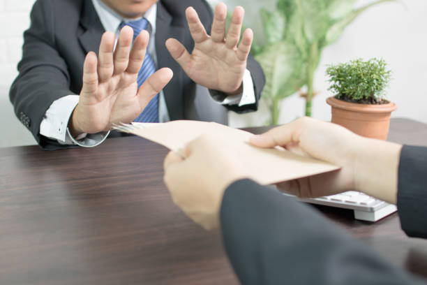 istock businessman refusing corruption by winking hand and stop recieving money 970891500