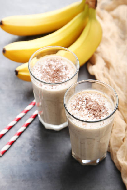 istock Cocktail with bananas in glasses on grey wooden table 970892320