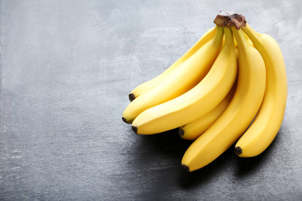 istock Sweet bananas on grey wooden table 970892894