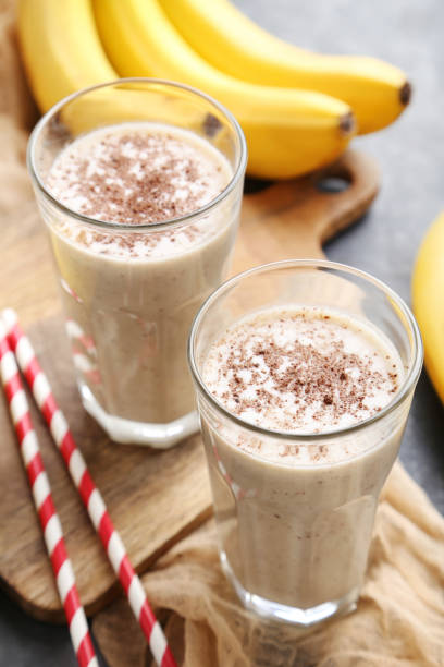 istock Cocktail with bananas in glasses on grey wooden table 970892962