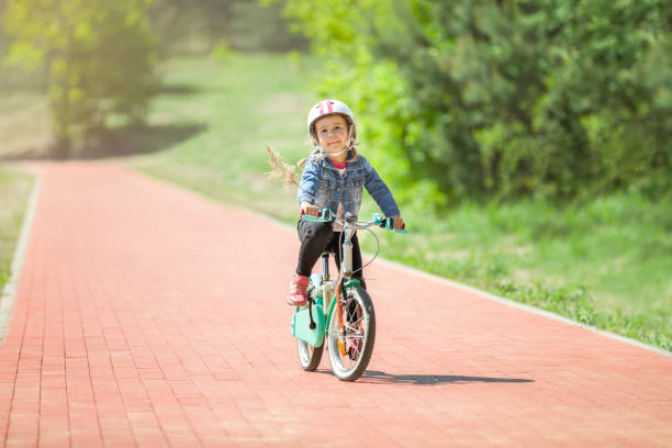 istock Cure little girl riding on bicycle 970895170