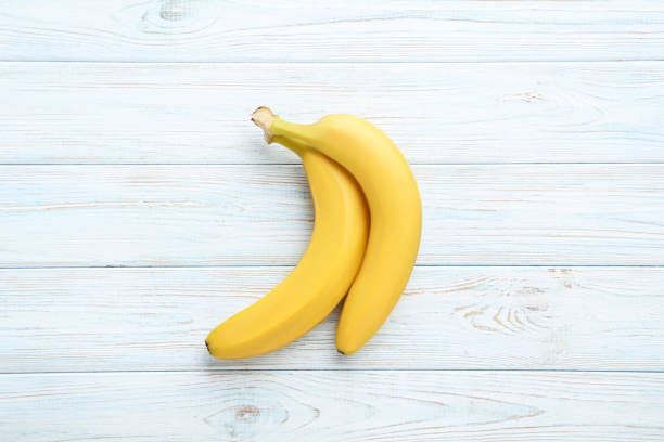 istock Sweet bananas on white wooden table 970895308