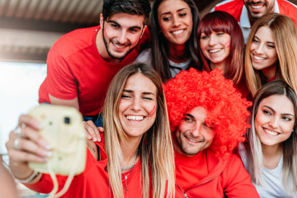 istock Fans at stadium together taking selfie with instant print camera 970895446