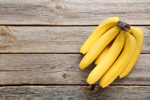 istock Sweet bananas on grey wooden table 970895710