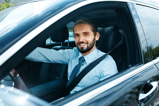Man Driving Car. Portrait Of Smiling Male Driving Car. Successful Young Business Man Going To Work In Comfortable Auto. High Resolution.