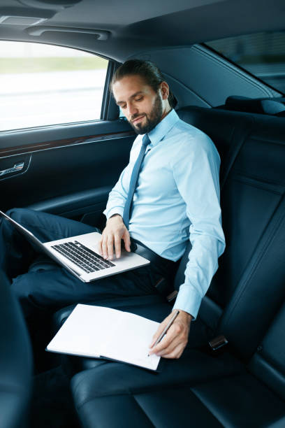 istock Portrait Of Business Man Working On Notebook, Traveling In Car. 970910708