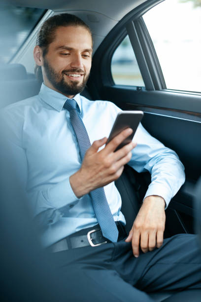 istock Young Successful Man Working On Phone Sitting In Car. 970915738