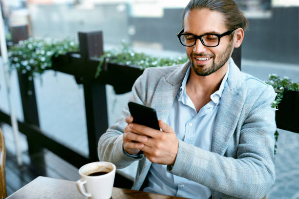 istock Man With Phone Drinking Coffee In Cafe 970919756