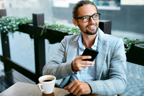 istock Man With Phone Drinking Coffee In Cafe 970919800