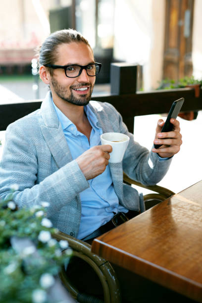 istock Man With Phone Drinking Coffee In Cafe 970919842