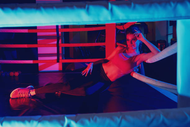 istock Woman in sportswear lying on boxing ring 970925452
